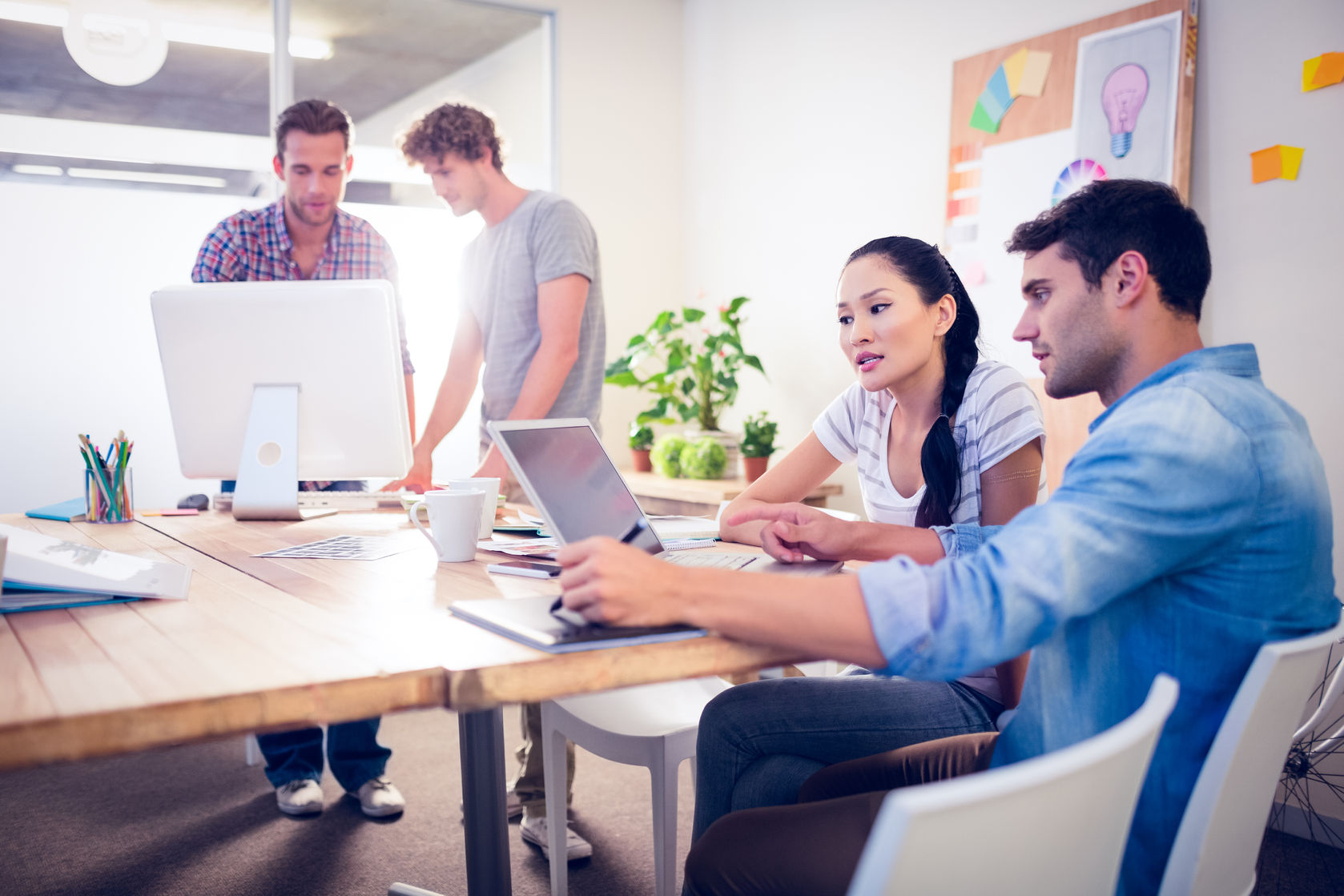 46070696 - creative business team gathered around laptops in the office